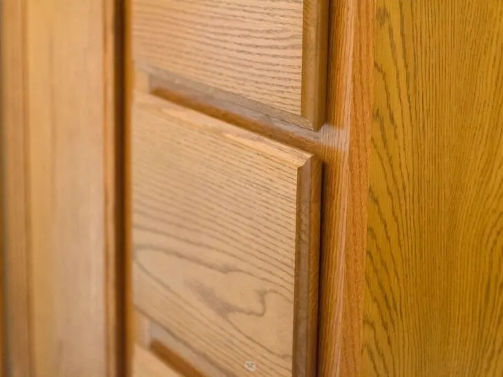 zoomed in view of orange oak cabinets and drawers.