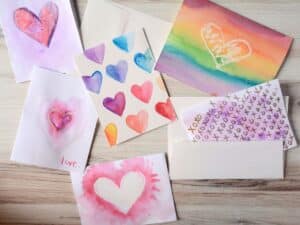 6 Valentine's Day cards with hearts done with watercolor paint.