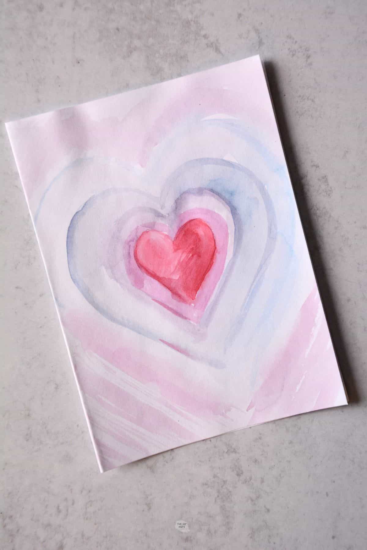 painted watercolor heart Valentine's card with purple and red paint.