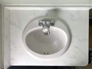 white marble painted bathroom counters with sink and faucet.