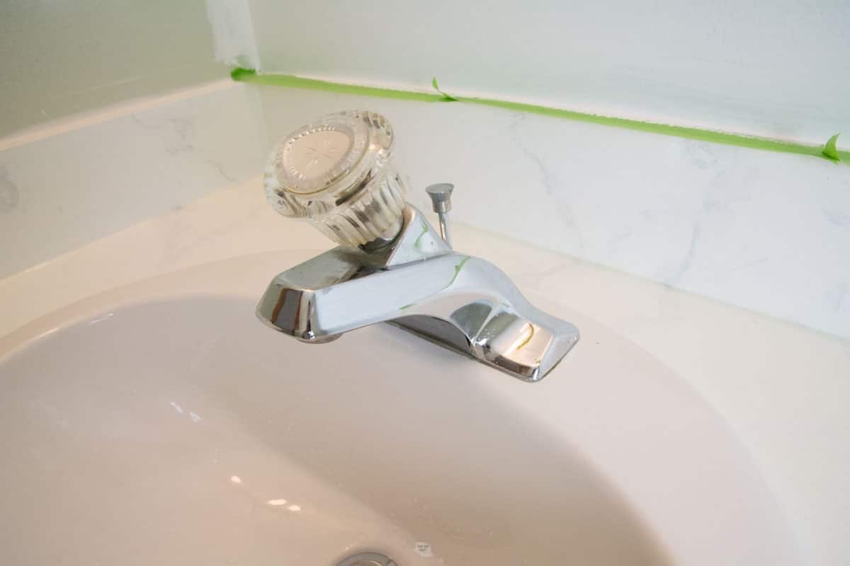 before chrome faucet with large knob on white sink.