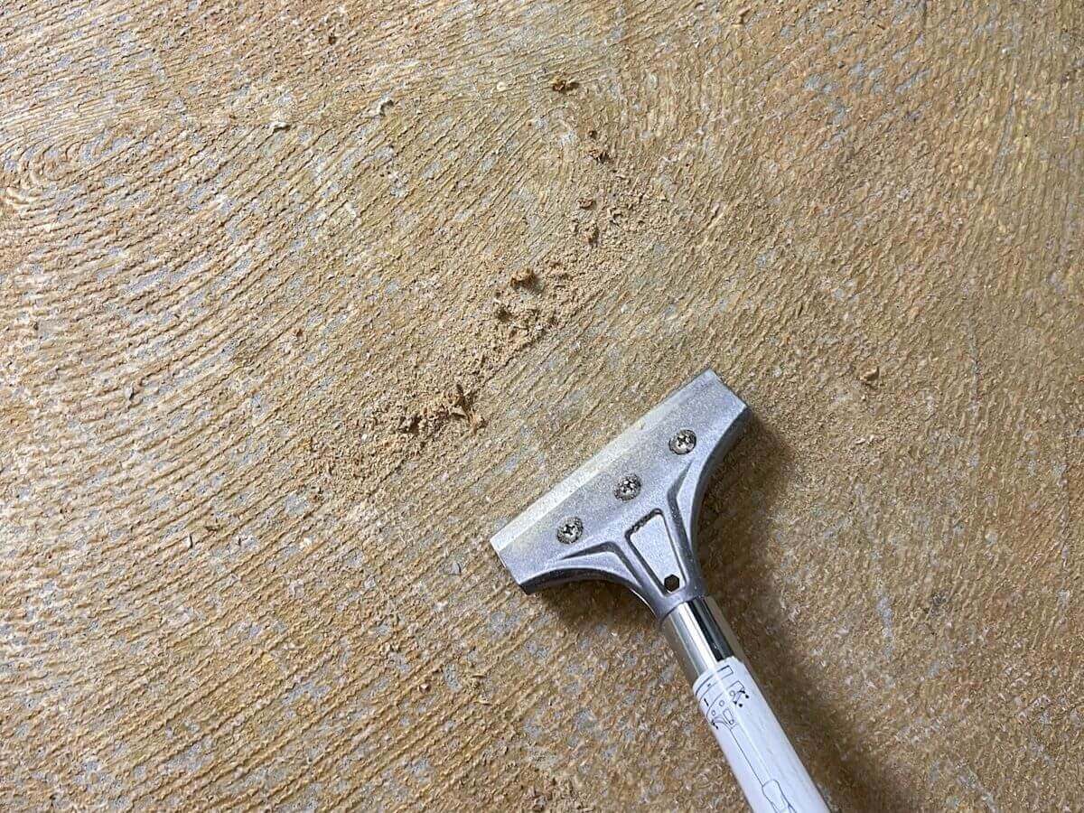 floor scraper getting carpet glue off of concrete.