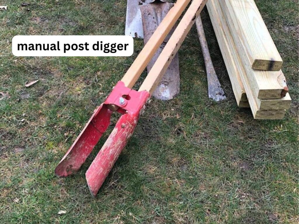 red manual post digger on wood.