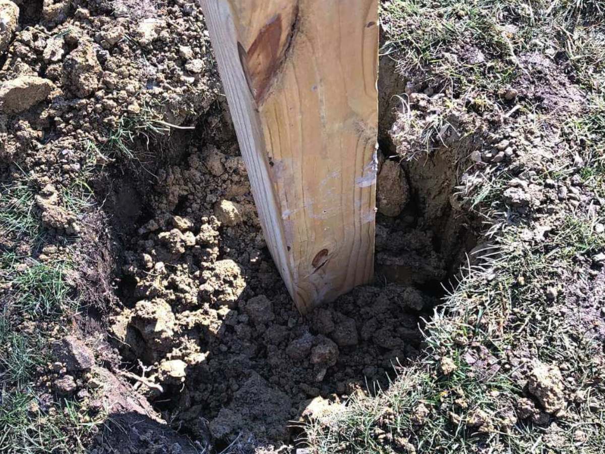 wooden post in concrete in ground.