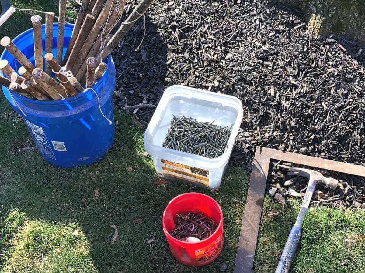 stakes, hammer, nails in buckets on ground.