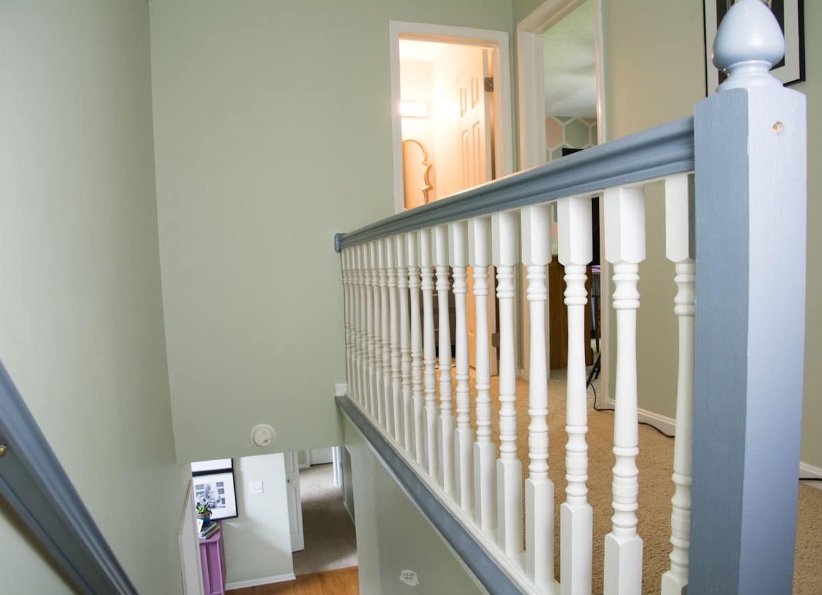 painted white spindles with blue gray hand rail and banister on stairs.