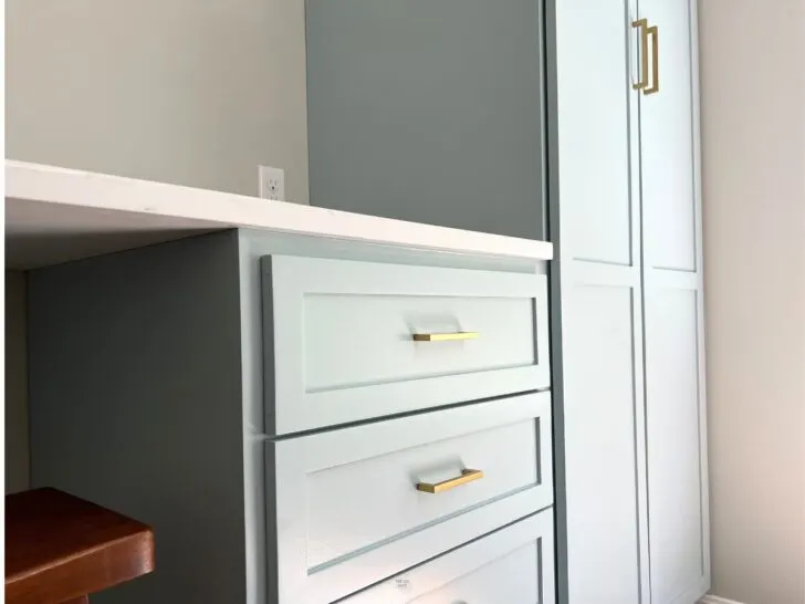 light blue painted drawers and built-in cabinets with white counter.