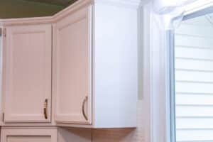 white painted upper kitchen cabinets with brushed nickel handles.