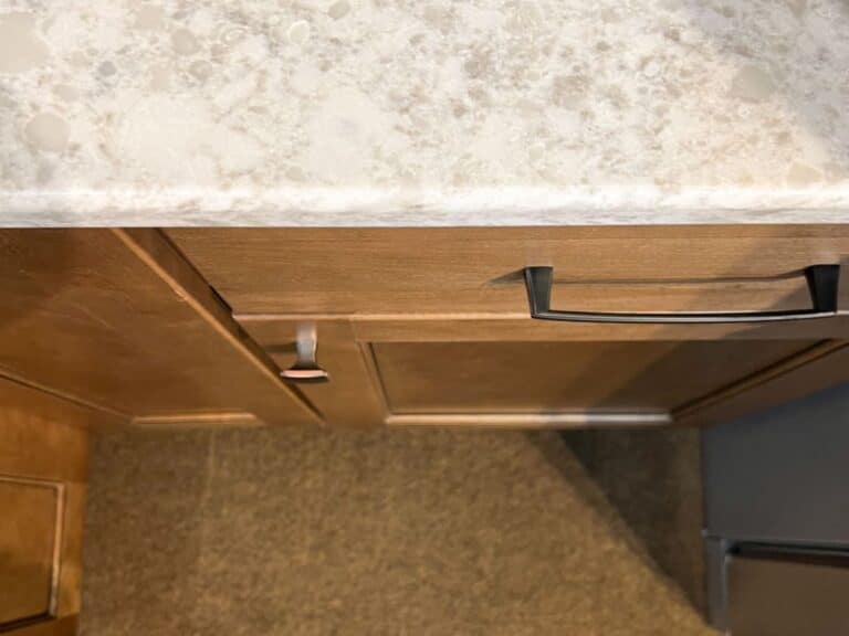 countertop and wood cabinets with handles.