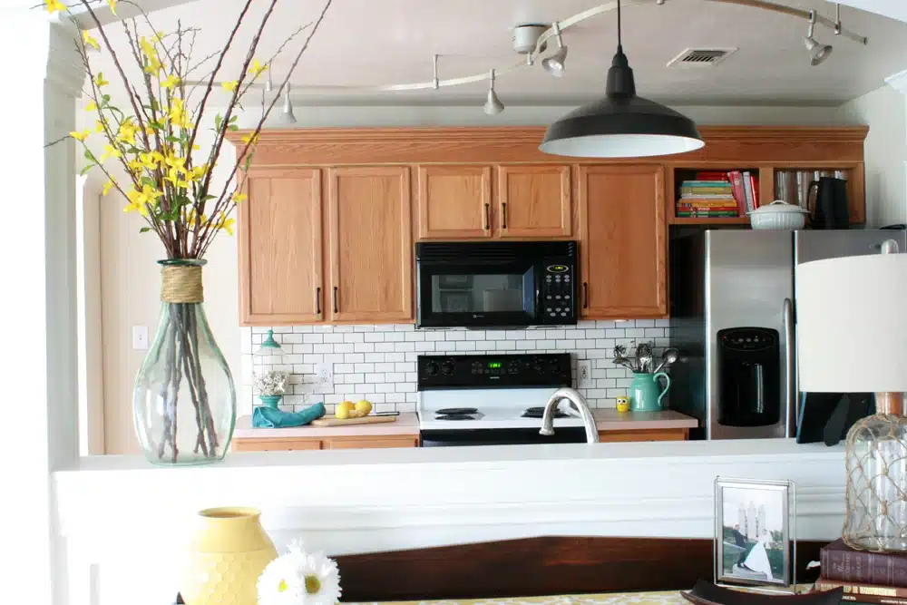 oak cabinets in kitchen with black and white color schemes.