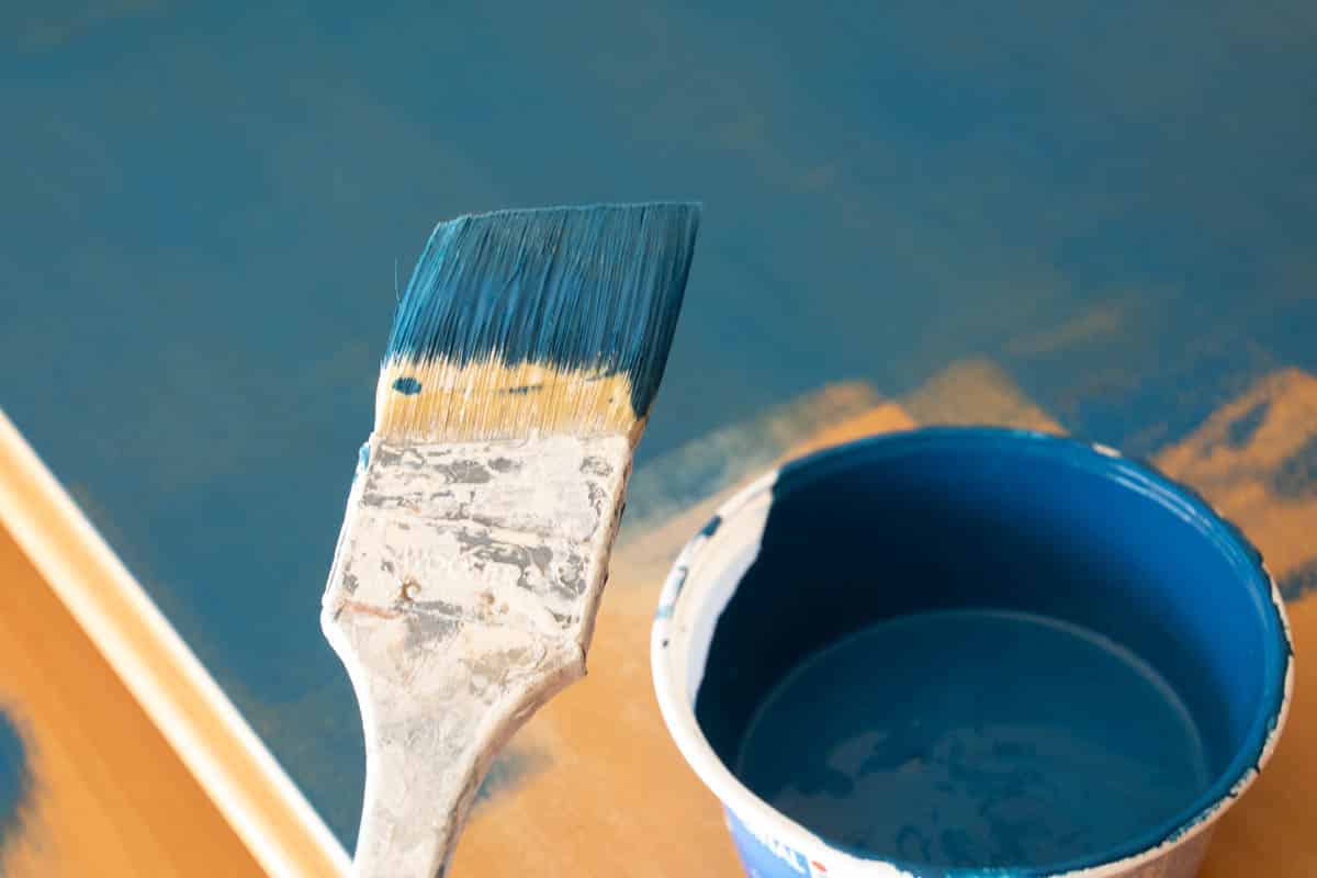 paint brush with blue chalk paint on it.