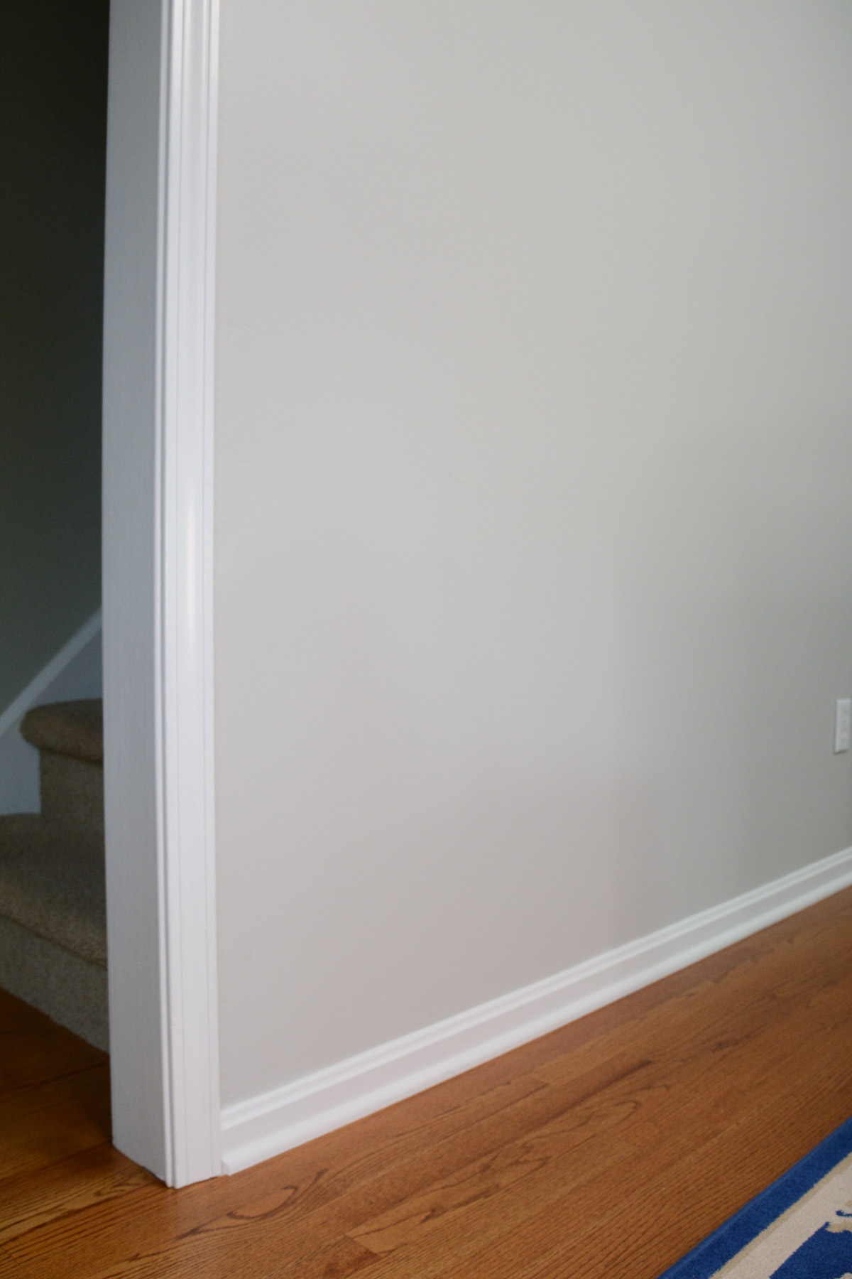 white trim and baseboards with gray walls and wood floor.
