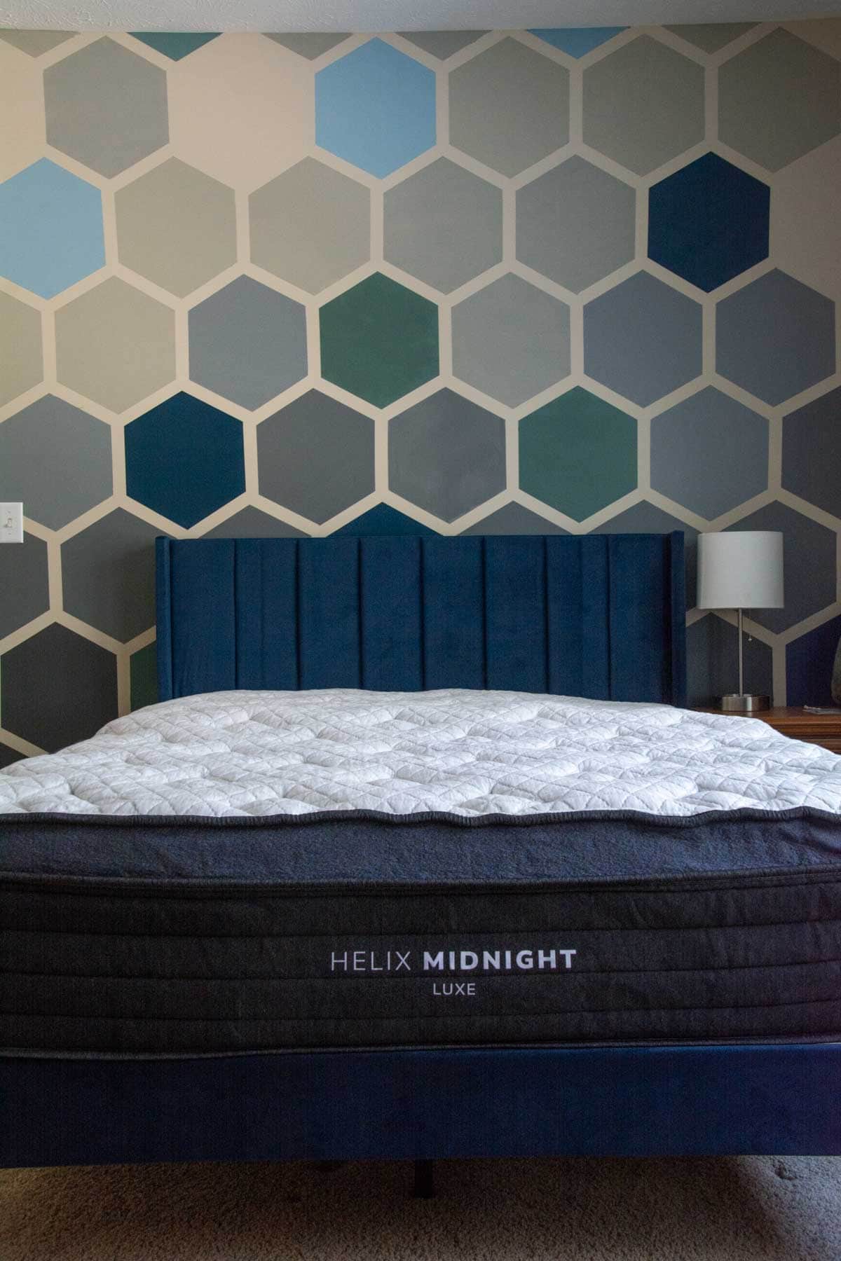 mattress, finished ombre hexagon wall on blue bed frame.